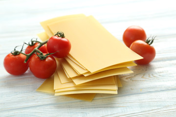 Lasagne sheets pasta with cherry tomato on a blue wooden table