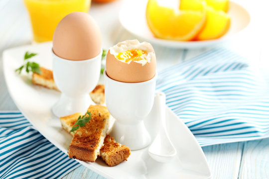 Boiled egg with toasts on a blue wooden table