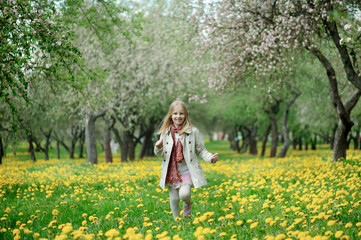 Fototapeta na wymiar Girl walks in the lush apple orchard