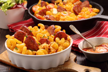 Casserole with chorizo sausage on wooden background