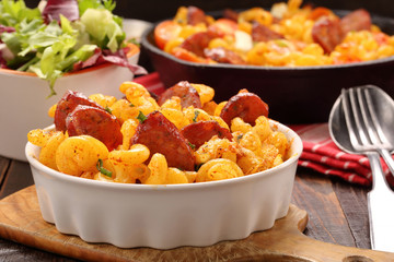 Casserole with chorizo sausage on wooden background