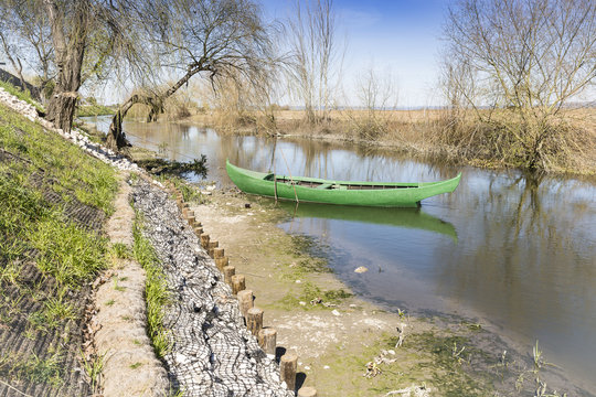 green canoe parked in the shore of a river in Azinhaga, Santarém, Portugal