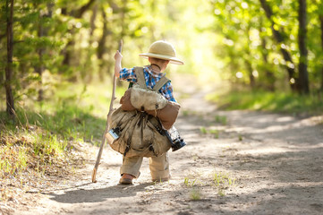 Fototapeta premium Boy on a forest road with backpacks