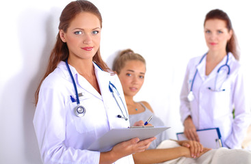 Fototapeta premium Smiling female doctor with a folder in uniform standing at hospital