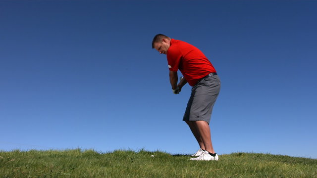 Golfer hits ball, slow motion
