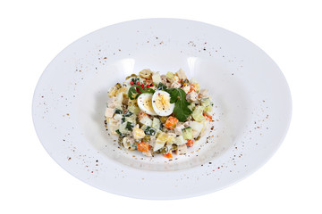 Olivier Russian meat salad with smoked chicken, on white plate.