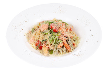 Serve pasta with red fish and vegetables on white plate.