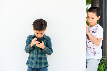 Young boy play smartphone compare with poor boy