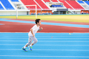 Boy runnin on blue track