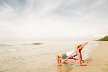 Woman lay on pink beach chair