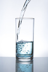 Concept of drinking. Pouring water from into glass