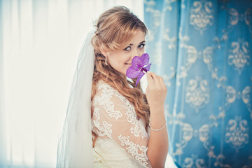 Happy and stylish cute blond bride dressing for her wedding in t