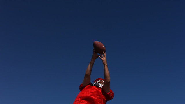 Football player catches ball, slow motion