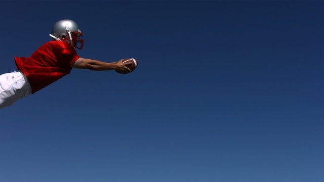 Football player dives for touchdown, slow motion