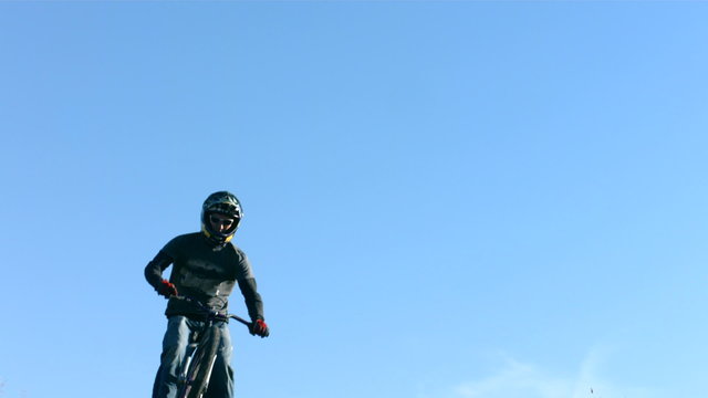 Mountain biker flies through air, slow motion