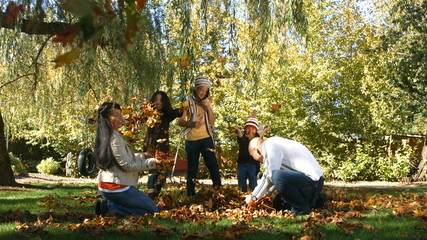 Family playing in the leaves - Powered by Adobe