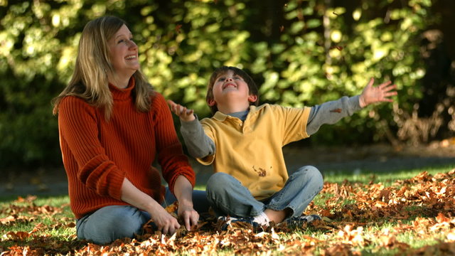 Mom and son playing in fallen leaves
