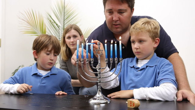 Family lighting a menorah