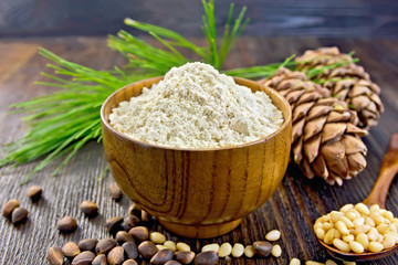 Flour cedar in bowl with nuts on wooden board