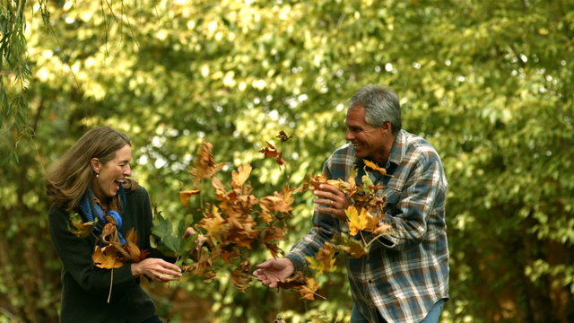 Couple playing in fallen leaves