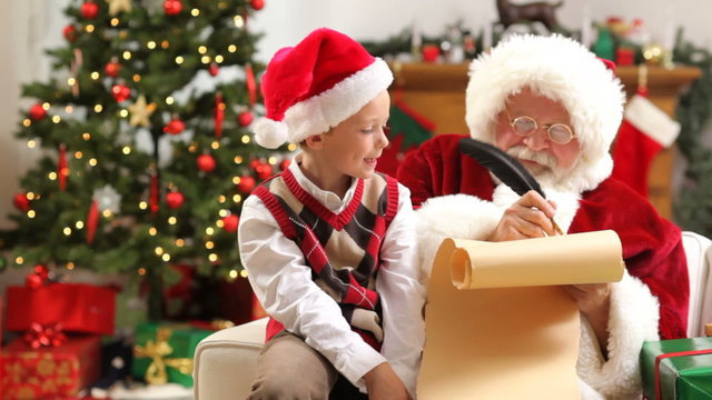 Santa Claus writes boys Christmas wishes on list
