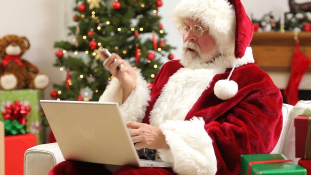 Santa Claus with laptop and cell phone
