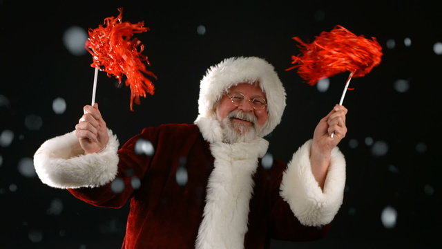 Santa Claus cheering with pom poms, slow motion