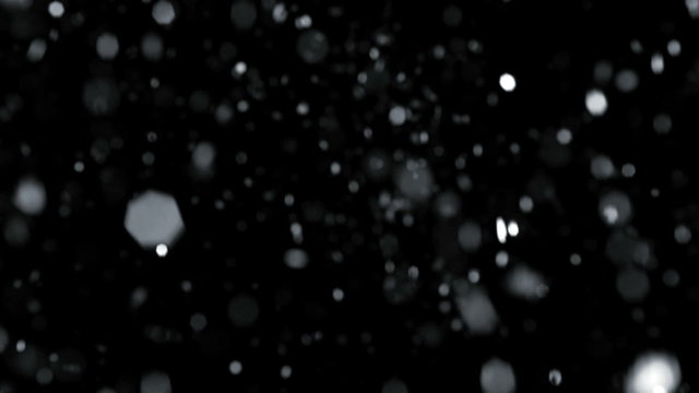 Snow drifting on black background