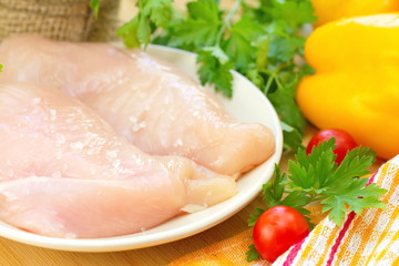 Raw chicken fillet with spices and vegetables