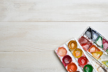 Used watercolor paints on a white wooden background. Top view of desktop. Creativity concept