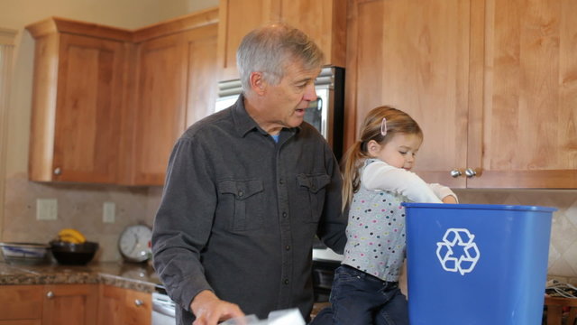 Grandpa and Grandchild in kitchen recycling