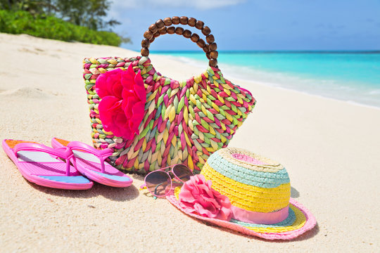 Bag, hat, flip-flops and sunglasses on sunny beach, tropical bea