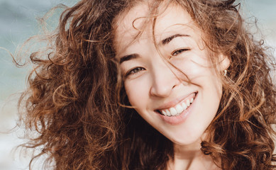 Close-up portrait of shine amazing woman jumping on the beach,white sand,vintage colors,full portrait,sensual lady,young girl posing in the beach,going crazy,funny mood,coolest