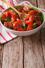 Homemade fresh tomato salad with herbs close up in a bowl. vertical
