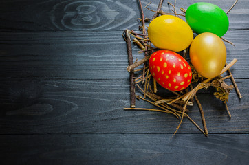 Easter eggs in branch nest on  wooden background