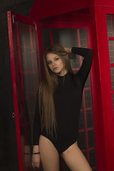Beautiful woman with a long hair at the phone booth