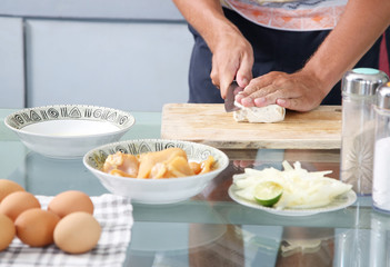 Man preparing meal in the kitchen - cutting tempeh