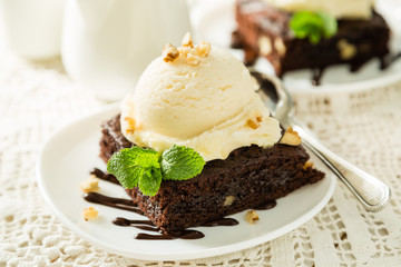 Chocolate brownie with vanilla ice cream, nuts and mint