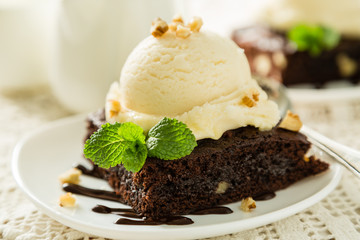 Chocolate brownie with vanilla ice cream, nuts and mint