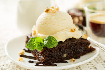 Chocolate brownie with vanilla ice cream, nuts and mint