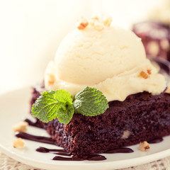 Chocolate brownie with vanilla ice cream, nuts and mint