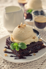 Chocolate brownie with vanilla ice cream, nuts and mint