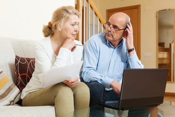  mature couple with documents and laptop