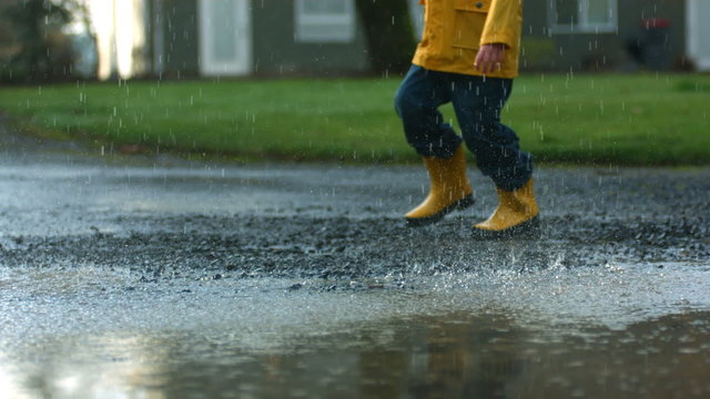 Child jumping into puddle