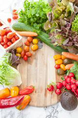 Frisches Gemuese um rustikales Schneidebrett