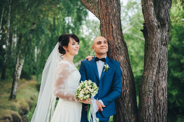The bride and groom hugging near a tree