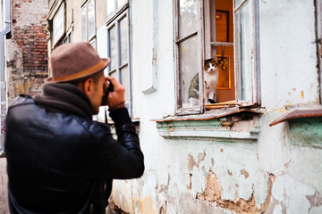 Man taking a picture of a cat