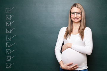 Pregnant woman and a blackboard with copyspace