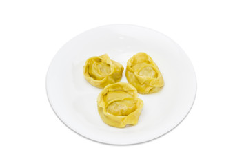 Three manti on a white dish on a light background