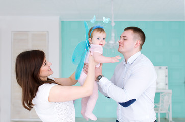 Obraz premium The father, mother and their little daughter play in room.